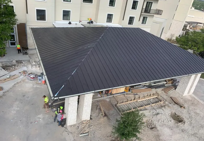 Metal roofing installation team working on a commercial building in Fort Smith